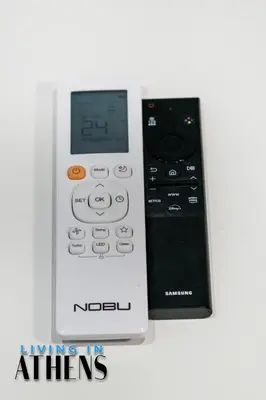 a remote control sitting next to a nintendoswersswersswersswersswers at Spacious Apt At Historical Center Of Athens 4&2 ppl in Athens