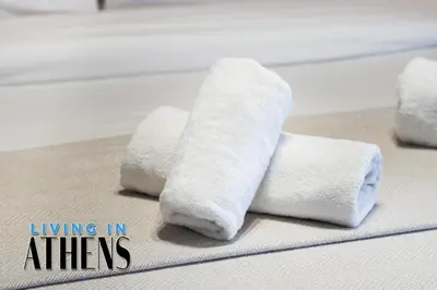 a pile of white towels sitting on a bed at Spacious Apt At Historical Center Of Athens 4&2 ppl in Athens