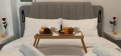 a tray with food and drinks on a bed at Cozy Νest Athens in Athens