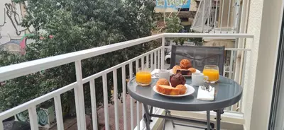 a table with breakfast food and orange juice on a balcony at Cozy Νest Athens in Athens