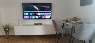 a living room with a table and a tv on the wall at Cozy Νest Athens in Athens
