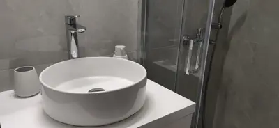 a bathroom with a white sink and a shower at Cozy Νest Athens in Athens