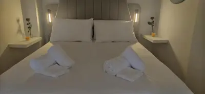 a bedroom with a white bed with two white pillows at Cozy Νest Athens in Athens