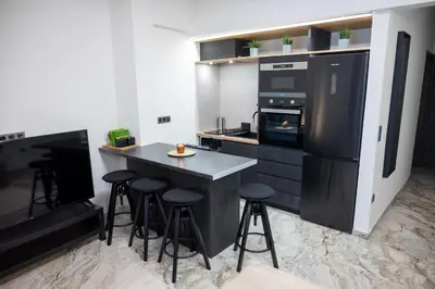 a kitchen with a island with bar stools in it at Athenee Suites in Athens