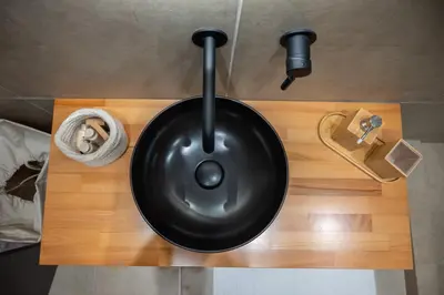 a black sink sitting on top of a wooden table at Athenee Suites in Athens