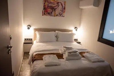a bedroom with a bed with towels on it at Athenee Suites in Athens