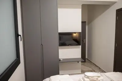 a bedroom with a bed and a tv on a wall at Athenee Suites in Athens
