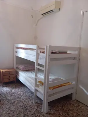 a bedroom with two bunk beds and a ladder at White Bunk Bed in dorm 5' from metro in Athens