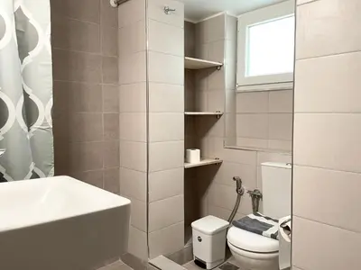 a bathroom with a sink and a toilet and a window at Acropolis Luminous Apartment in Athens