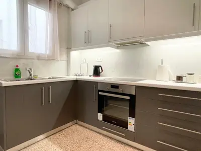 a kitchen with grey and white cabinets and a sink at Acropolis Luminous Apartment in Athens
