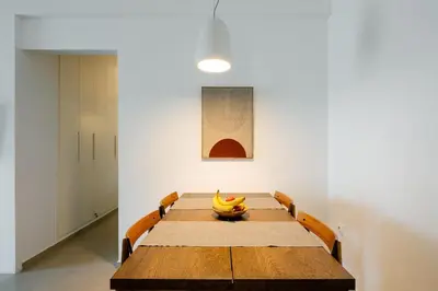 a wooden table with a bowl of bananas on it at Bright and breezy by the sea in Athens