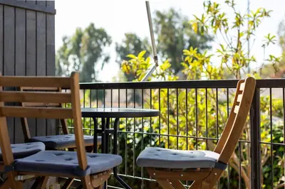 two chairs and a table on a balcony at Bright and breezy by the sea in Athens