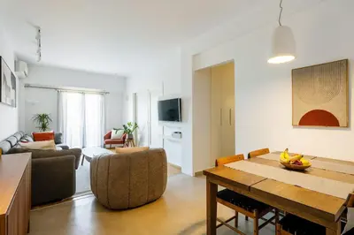 a living room with a dining room table and a living room with at Bright and breezy by the sea in Athens