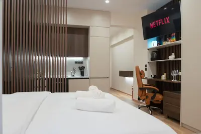 a bedroom with a large white bed and a chair at Luxury Suite 100m from Shore and Tram in Athens
