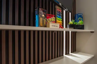 a shelf with games and books on it at Luxury Suite 100m from Shore and Tram in Athens
