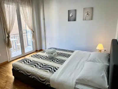 a large bed in a room with a window at Kalithea Spartis appartment in Athens