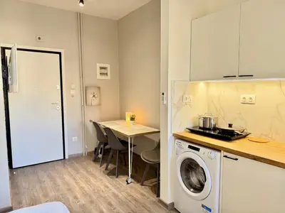 a kitchen with a washing machine and a table at Kalithea Spartis appartment in Athens