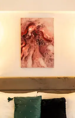a painting above a bed with a green pillow at Acropolis Retreat Stay in Style in Athens