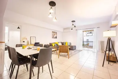 a dining room and living room with a table and chairs at Acropolis Retreat Stay in Style in Athens