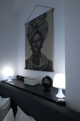 a painting of a woman on a bed with two lamps at steps to Lycabettus in Athens