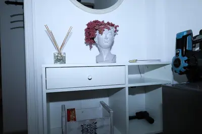 a white dresser with a statue of a head on it at steps to Lycabettus in Athens