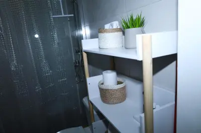 a bathroom with white shelves and a shower with plants at steps to Lycabettus in Athens