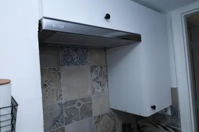 a kitchen with a stove and a white cabinet at steps to Lycabettus in Athens