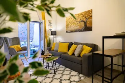 a living room with a gray couch and yellow pillows at Panathenaic Stadium 1bed Luxury in Athens