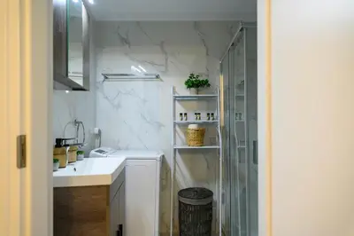 a white bathroom with a sink and a shower at Panathenaic Stadium 1bed Luxury in Athens