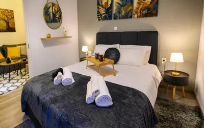 a bedroom with a bed with two pairs of shoes on it at Panathenaic Stadium 1bed Luxury in Athens