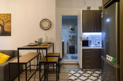 a kitchen with a table and a kitchen with a refrigerator at Panathenaic Stadium 1bed Luxury in Athens