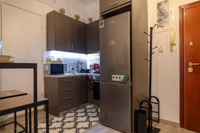 a kitchen with a stainless steel refrigerator and a table at Panathenaic Stadium 1bed Luxury in Athens