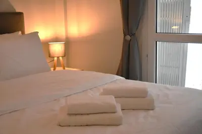 a bedroom with a white bed with towels on it at Athens Quite Flat, Vibrant neighborhood & Large Balcony in Athens
