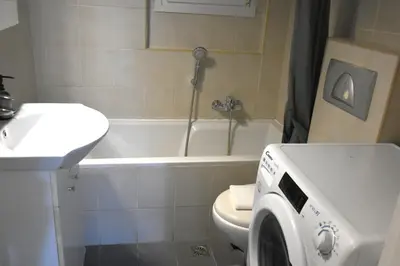 a bathroom with a washing machine next to a toilet at Athens Quite Flat, Vibrant neighborhood & Large Balcony in Athens