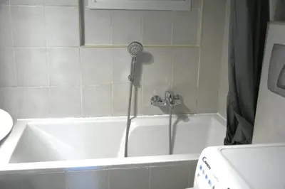 a white bath tub with a shower in a bathroom at Athens Quite Flat, Vibrant neighborhood & Large Balcony in Athens