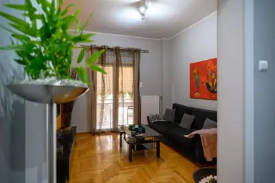 a living room with a black couch and a plant at Cosy Pangrati Urban Retreat in Athens