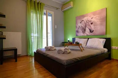 a bedroom with a bed with a painting of a horse at Cosy Pangrati Urban Retreat in Athens