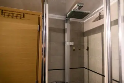 a bathroom with a shower with a ceiling fan at Cosy Pangrati Urban Retreat in Athens