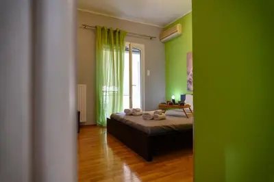 a room with a bed with green walls and a window at Cosy Pangrati Urban Retreat in Athens