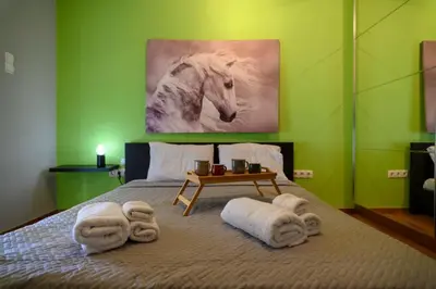 a bedroom with a bed with towels and a picture of a horse at Cosy Pangrati Urban Retreat in Athens