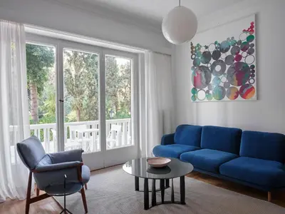 a living room with a blue couch and a table at Anaktora Gardens Apt in Athens