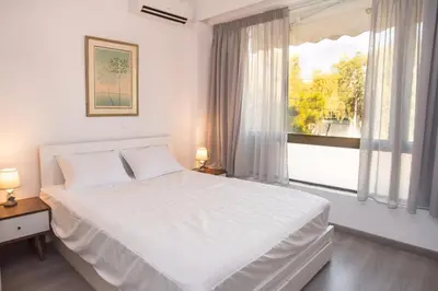 a bedroom with a white bed and a window at Beachside Bliss Central 1-Bedroom in Glyfada in Athens