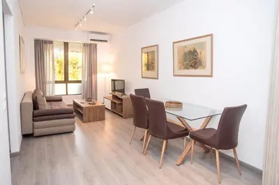 a living room with a dining room table and chairs at Beachside Bliss Central 1-Bedroom in Glyfada in Athens