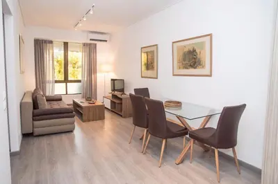 a dining room and living room with a table and chairs at Beachside Bliss Central 1-Bedroom in Glyfada in Athens