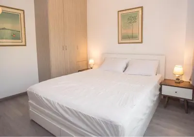 a bedroom with a large white bed with two lamps at Beachside Bliss Central 1-Bedroom in Glyfada in Athens
