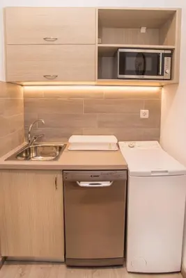 a small kitchen with a sink and a microwave at Beachside Bliss Central 1-Bedroom in Glyfada in Athens