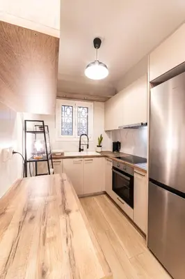 a kitchen with white cabinets and a wooden table at Athenian Heaven II in Athens