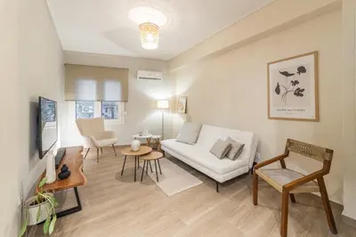 a living room with a white couch and a table at Athenian Heaven II in Athens