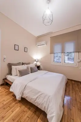 a bedroom with a large white bed and a window at Athenian Heaven II in Athens