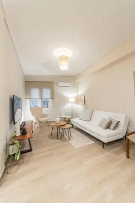 a living room with a white couch and a table at Athenian Heaven II in Athens